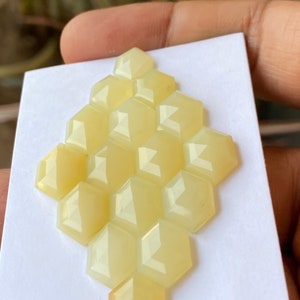Peut inclure: Un groupe de 12 cabochons hexagonaux facet&eacute;s de couleur jaune dispos&eacute;s en forme de nid d'abeille.
