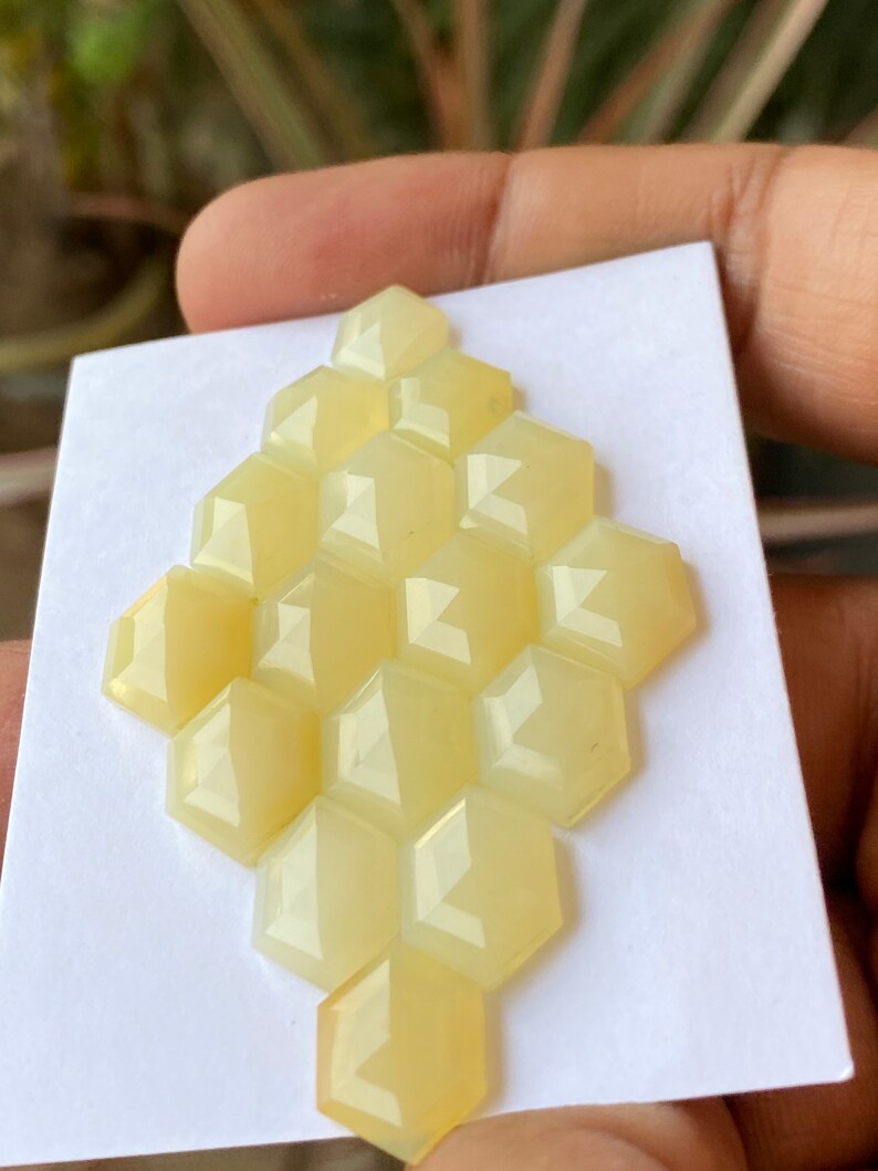 Peut inclure: Un groupe de 12 cabochons hexagonaux facet&eacute;s de couleur jaune dispos&eacute;s en forme de nid d'abeille.