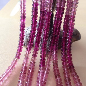 May include: Multiple strands of faceted pink and magenta gemstones. The beads are strung together, creating a gradient effect from light pink to deep magenta. The gemstones are displayed against a neutral background.