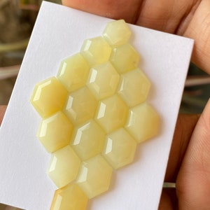 Peut inclure: Un groupe de 12 cabochons hexagonaux de couleur jaune dispos&eacute;s en forme de nid d'abeille. Les cabochons sont lisses et polis.