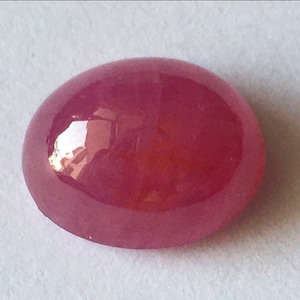 Peut inclure: Une pierre précieuse de rubis rose ovale et lisse.