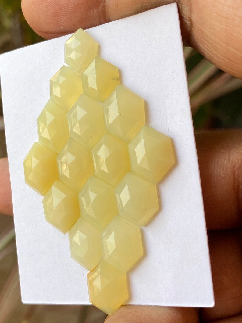 Peut inclure: Un groupe de 12 pierres pr&eacute;cieuses hexagonales en cabochon jaune p&acirc;le dispos&eacute;es en forme de nid d'abeille.