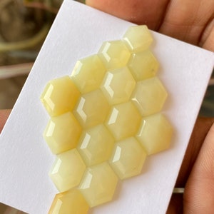 Peut inclure: Un groupe de 12 pierres pr&eacute;cieuses hexagonales en cabochon jaune p&acirc;le dispos&eacute;es en forme de nid d'abeille.