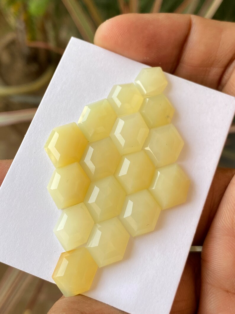 Peut inclure: Un groupe de 12 pierres pr&eacute;cieuses hexagonales en cabochon jaune p&acirc;le dispos&eacute;es en forme de nid d'abeille.