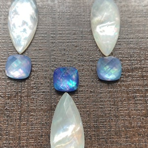 May include: A pair of teardrop-shaped earrings with iridescent white mother of pearl and blue opal stones.