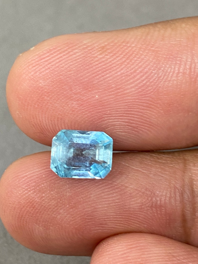 Peut inclure: Une pierre pr&eacute;cieuse bleu clair de taille &eacute;meraude carr&eacute;e.