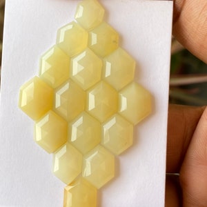 Peut inclure: Une collection de 14 pierres pr&eacute;cieuses hexagonales en cabochon jaune p&acirc;le dispos&eacute;es en forme de nid d'abeille.