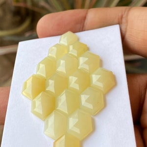 Peut inclure: Un groupe de 12 cabochons hexagonaux facet&eacute;s de couleur jaune dispos&eacute;s en nid d'abeille sur un fond blanc.