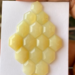 Peut inclure: Une collection de 16 pierres pr&eacute;cieuses hexagonales en cabochon jaune p&acirc;le dispos&eacute;es en forme de nid d'abeille.