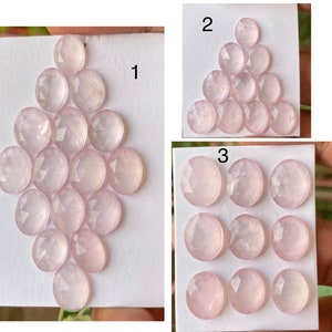 Könnte beinhalten: Rosenquarz-Edelsteine in verschiedenen Anordnungen. Die Steine sind oval geformt mit facettierten Oberflächen und weisen einen zarten rosa Farbton auf. Das Bild zeigt mehrere Gruppierungen dieser Edelsteine, die ihre Farbe und ihren Schliff hervorheben.