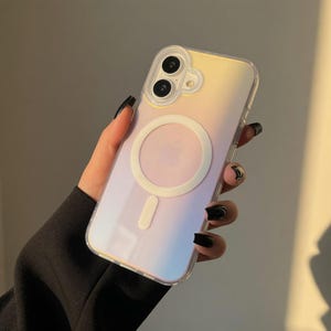 May include: A clear phone case with a gradient of yellow, pink, and blue hues. The case features a white circular MagSafe charger and a white rectangular charging indicator. The phone case has a dual-lens camera cutout.