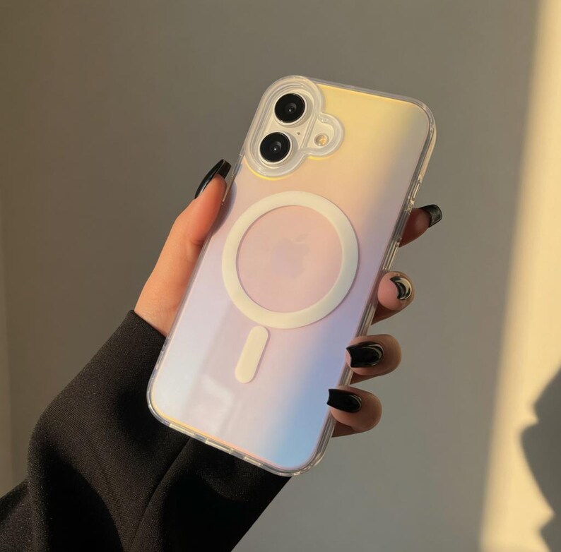 May include: A clear phone case with a gradient of yellow, pink, and blue hues. The case features a white circular MagSafe charger and a white rectangular charging indicator. The phone case has a dual-lens camera cutout.