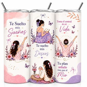 May include: Three cylindrical tumblers with metal straws featuring illustrations of a person with long brown hair, butterflies, flowers, and Spanish text including Te Suelto mis Sueños, Te suelto mis Deseos, Toma el control de mi Vida, and Tu plan anhelo mas que al Mio.
