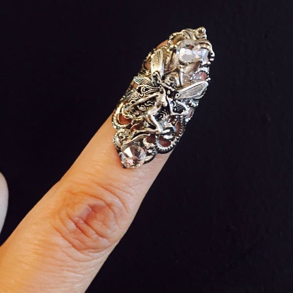 Fairy claw ring, nail guard or finger tip made in a dull silver color, adorned with a fairy charm and clear crystals ,sizable.