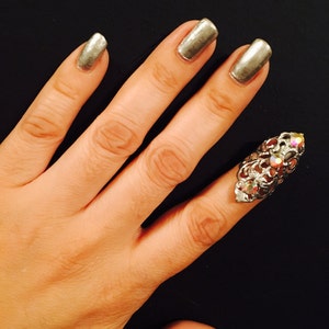 Single crystal claw ring ir nail ring, made in silver color filigree and adorned with clear ab crystals.
