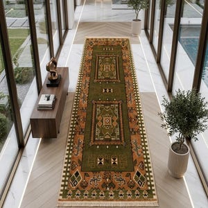 Peut inclure: Un long tapis de couloir rectangulaire présentant un champ central vert olive avec des motifs géométriques complexes en orange, crème et noir. Le tapis possède une bordure décorative et des extrémités à franges, placé dans un couloir lumineux.