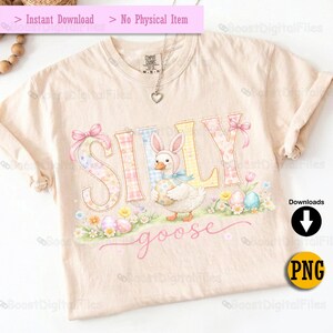 May include: A light beige t-shirt featuring the word "SILLY" in pastel colors with floral and plaid patterns. A cartoon goose wearing a bunny bonnet and holding an Easter egg is in the center. The word "goose" is written in cursive below.