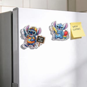 May include: Two acrylic magnets featuring the blue character Stitch. One magnet shows Stitch wearing a yellow cap and glasses, holding a blue crayon next to a sign that reads READY TO LEARN. The other shows Stitch holding a yellow pencil near books and an apple.