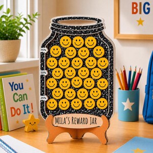 May include: A wooden reward jar shaped like a mason jar with a black and white star pattern. It features rows of yellow smiley face tokens and progress markers at 25%, 50%, and 75%. The base is labeled with the text Mila's Reward Jar.
