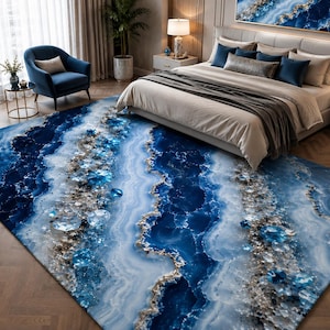 May include: A large rectangular area rug featuring a vibrant blue and white agate stone pattern with shimmering gold-toned accents and crystalline textures that mimic the appearance of natural gemstone slices across the entire surface.