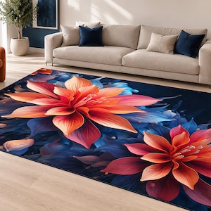 May include: A rectangular area rug featuring a large-scale floral pattern with vibrant orange and red petals set against a deep navy blue background. The design showcases two prominent, stylized blossoms with layered petals and soft blue foliage.