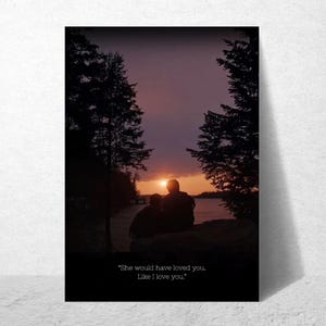 Puede incluir: Impresión enmarcada que muestra la silueta de dos personas contemplando una puesta de sol sobre un lago. El cielo es una gradación de naranja a púrpura, con árboles que enmarcan la escena. El texto en la parte inferior dice: "She would have loved you. Like I love you."