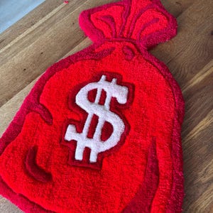 Money Bag Rug – Rood Geldzak Tapijt met Dollar Teken – Uniek Handgemaakt Vloerkleed – Statement Home Decor | 53 x 33 cm