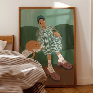 Könnte beinhalten: Ein gerahmter Kunstdruck zeigt eine Person in einem gestreiften Kleid, die auf einem grünen Sofa sitzt und eine Kaffeetasse hält. Eine orangefarbene Katze ruht auf Papieren in der Nähe. Das Kunstwerk verwendet eine warme Farbpalette mit Braun-, Grün- und Blautönen. Der Druck ist gerahmt.