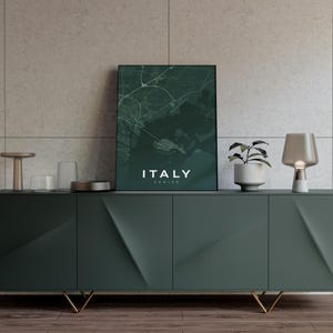 Pode incluir: Uma impress&atilde;o emoldurada do mapa da It&aacute;lia, com Veneza em destaque. O mapa &eacute; em tons de verde e branco, com as palavras "ITALY" e "VENICE" impressas em branco. A impress&atilde;o est&aacute; em um arm&aacute;rio verde escuro.