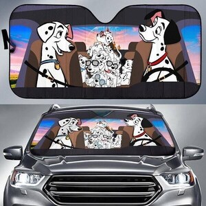 May include: A black and white Dalmatian-themed car sunshade featuring a cartoon image of the Disney movie 101 Dalmatians. The sunshade depicts the dogs in a car, with a sunset background.