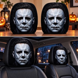 Könnte beinhalten: Zwei schwarze Kopfstützenbezüge für das Auto mit einem detaillierten, realistischen Druck der Michael Myers-Maske. Das Design zeigt ein blasses, strukturiertes Gesicht mit dunklen, hohlen Augenhöhlen und dunklem Haar auf schwarzem Grund.