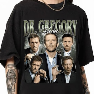 以下が含まれることがあります： テレビドラマ「House」のDr. Gregory Houseのグラフィックが特徴の黒いTシャツ。キャラクターの複数の画像と、ヴィンテージスタイルのテキスト「DR. GREGORY House」が含まれています。