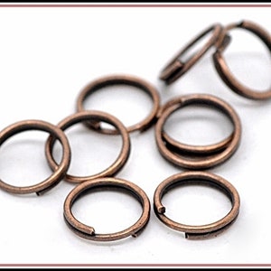 May include: A group of eight small, copper-colored jump rings. The rings are all the same size and are arranged in a loose pile.