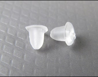 May include: Two clear plastic earring backs. The backs are shaped like a small cone with a flat top.