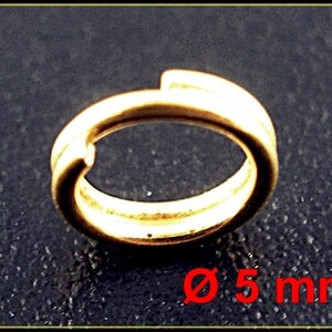 May include: A gold-coloured metal jump ring with a 5 mm diameter.
