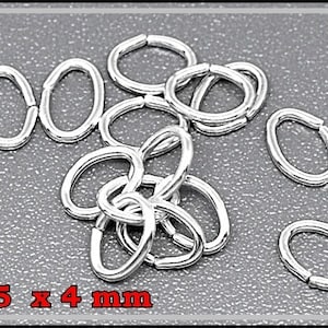 以下が含まれることがあります： 5.5 x 4 mm の銀製のジャンプリングが積み重ねられている様子のクローズアップ。リングは楕円形で、滑らかで磨かれた仕上げになっています。