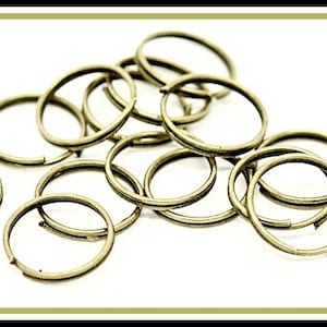 May include: A pile of gold-coloured metal key rings. The rings are all different sizes and are arranged in a random pattern.