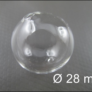 May include: A clear glass sphere with a diameter of 28 mm. The sphere has a small opening at the top.