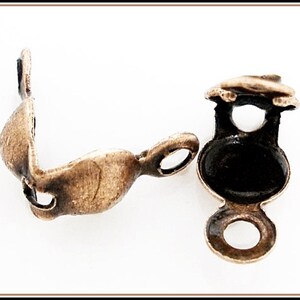 May include: Two antique gold-toned metal corner connectors for jewellery making. Each connector has a round loop on one end and a curved, open-ended design on the other.