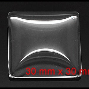 May include: A clear glass square with rounded edges and a slight curve in the center. The glass measures 30 mm x 30 mm.