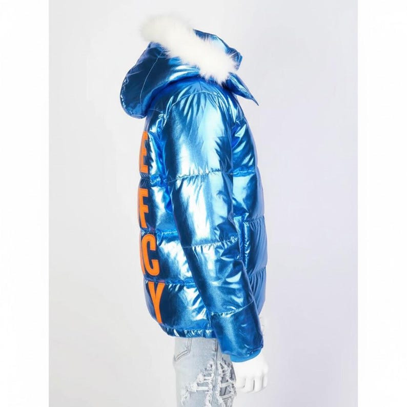 May include: A shiny, metallic blue puffer jacket with a hood trimmed with white faux fur. The jacket features the word "FANCY" in orange block letters down the side. The jacket is a winter outerwear item.