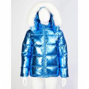 May include: A shiny, metallic blue puffer jacket with a white faux fur-lined hood. The jacket has a zip-up front and a small logo on the chest. The jacket is displayed on a mannequin.