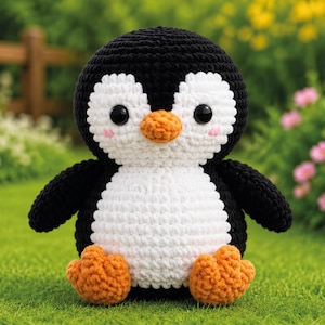 Op de afbeelding: Een gehaakte pinguïnknuffel met een zwarte kop en rug, een wit gezicht en buik, een oranje snavel en oranje voeten. Het speelgoed heeft twee grote, ronde, zwarte plastic ogen en kleine roze geborduurde cirkels op de wangen.