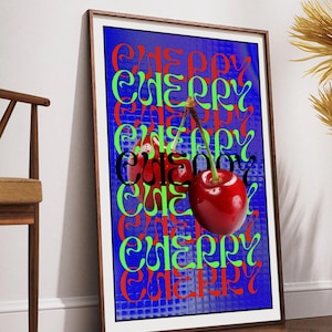 May include: Framed art print showing two cherries with stems. The word "CHERRY" is repeated in red, green, and black over a blue background. The artwork is displayed on a wooden floor.