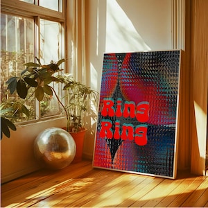 May include: A framed art print with the words "Ring Ring" in red, set against a colourful abstract background of red, blue, and black. A disco ball and potted plants sit near a window, with sunlight illuminating the wooden floor.