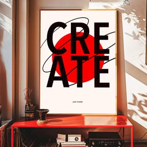May include: A framed art print featuring the word "CREATE" in large, black, grid-patterned letters over a red circle. The phrase "just create" is printed below. The artwork is displayed on a red table.