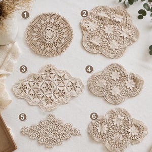 May include: A collection of eight beige crochet doilies labeled with numbers one through eight. The pieces feature various intricate openwork patterns, including floral motifs, circular designs, and scalloped edges, all crafted from light-colored thread.