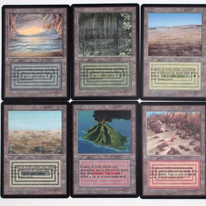 Puede incluir: Una colección de diez cartas coleccionables de Magic: The Gathering. Cada carta presenta una pintura de paisaje, incluyendo montañas, desiertos e islas. Las cartas tienen una estética vintage con un borde marrón y texto en la parte inferior.