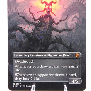 Peut inclure: Carte Magic: The Gathering avec Sheoldred, l'Apocalypse. L'illustration montre une cr&eacute;ature monstrueuse aux couleurs rouge et violet. Le texte d&eacute;crit des capacit&eacute;s comme le contact mortel et le gain/perte de vie. La force/endurance de la carte est de 4/5.