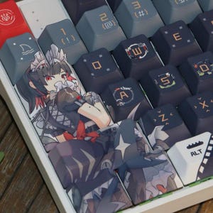 May include: A close-up of a mechanical keyboard with custom keycaps. The keycaps feature anime-style artwork and various symbols. The keyboard has a white frame and a variety of colors.